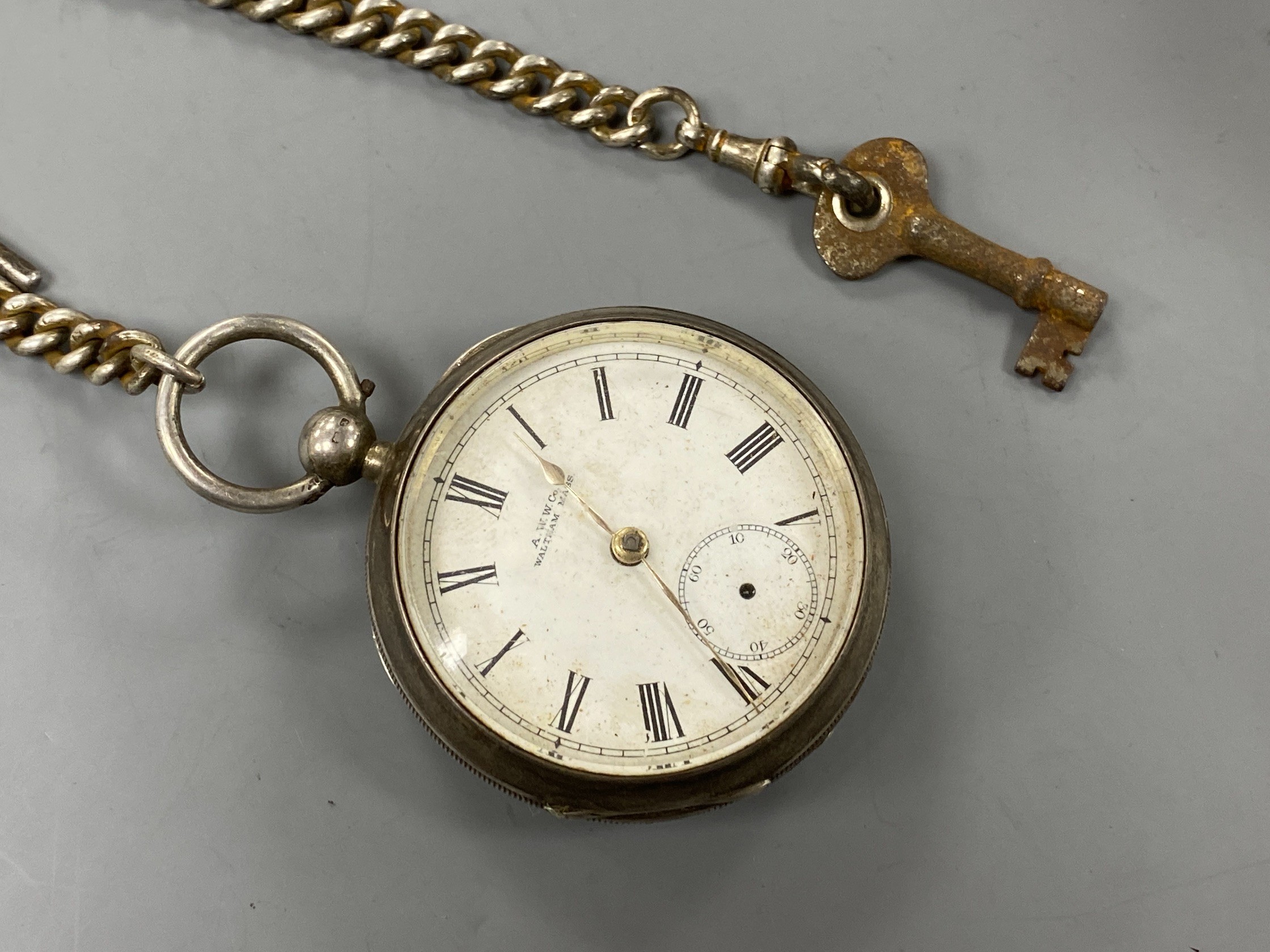 A late Victorian Waltham silver open faced key wind pocket watch, on a silver albert.